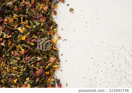 Dry herbal tea and green tea as frame on white background. View from above. Copy space. Dry tea leaves texture. Dry herbal tea and green tea as frame on white background. View from above. Copy space. Dry tea leaves texture. 123943746