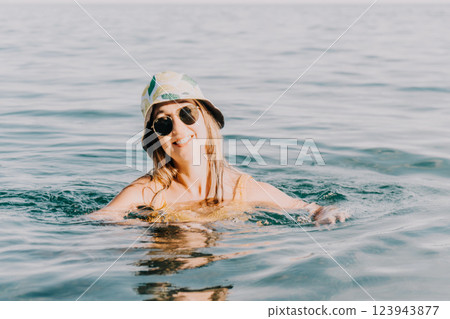 Woman Sunglasses Water - Young woman wearing sunglasses swims in a body of water, likely a lake or ocean, on a warm day, enjoying the cool water. Woman Sunglasses Water - Young woman wearing sunglasses swims in a body of water, likely a lake or ocean, on a warm day, enjoying the cool water. 123943877