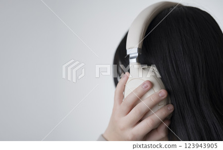女孩透過耳機聽音樂。音樂、聲音、聆聽、學習、廣播、學習等。 123943905