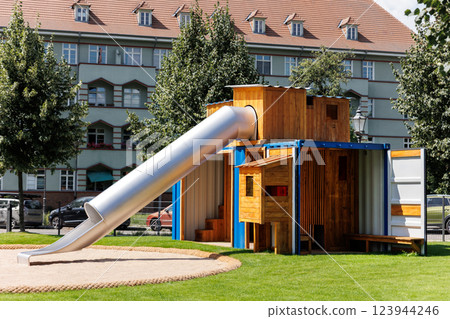 New modern eco children playground at residential apartments house courtyard made upcycled metal cargo container. Portable playing area equipment facility city condo district in Germany New modern eco children playground at residential apartments house courtyard made upcycled metal cargo container. Portable playing area equipment facility city condo district in Germany 123944246