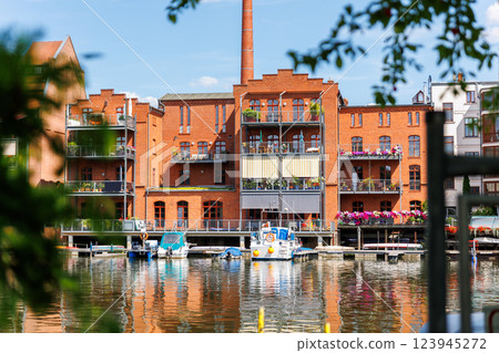 Scenic view of Brandenburg an der Havel new modern apartment house district waterfront yachts boats river canal pond bright summer day. Historical industrial building upcycling renewal restoration Scenic view of Brandenburg an der Havel new modern apartment house district waterfront yachts boats river canal pond bright summer day. Historical industrial building upcycling renewal restoration 123945272