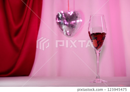 Wine glass with heart confetti and disco on pink background Wine glass with heart confetti and disco on pink background 123945475