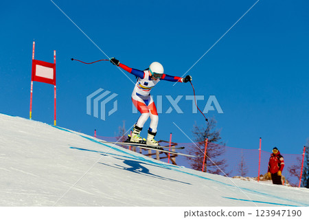 woman ski racer jump landing during competitive downhill skiing 123947190