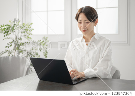 經營個人電腦的中年婦女 經營個人電腦的中年婦女 123947364