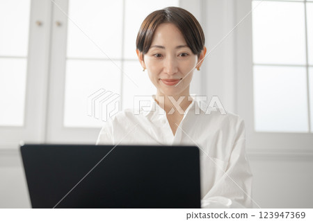 經營個人電腦的中年婦女 經營個人電腦的中年婦女 123947369