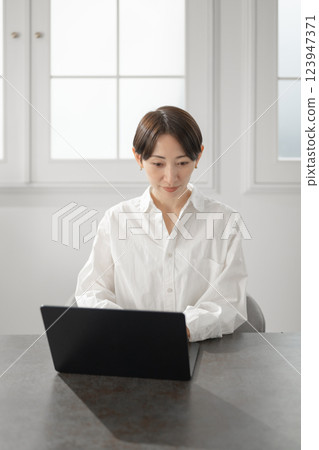 經營個人電腦的中年婦女 經營個人電腦的中年婦女 123947371