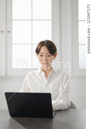 經營個人電腦的中年婦女 經營個人電腦的中年婦女 123947373