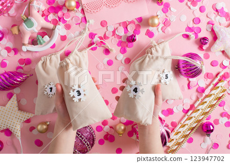 Christmas advent calendar with gift velvet bags and wooden numbers on a white background. Eco-friendly 123947702