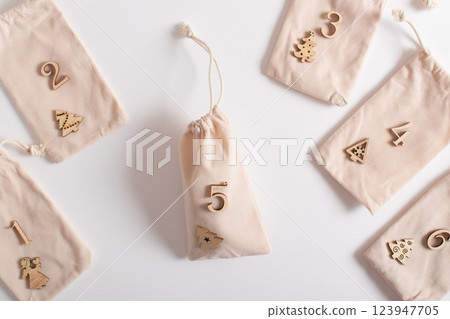 Christmas advent calendar with gift velvet bags and wooden numbers on a white background. Eco-friendly Christmas advent calendar with gift velvet bags and wooden numbers on a white background. Eco-friendly 123947705