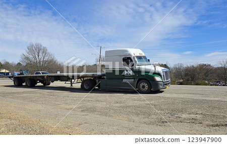 Freight liner Semi-Truck Driving on Open Highway in a Rural Area, CDL Truck  showcasing commercial transportation, logistics efficiency, and professional trucking 123947900