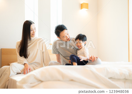 Family sitting on bed 123948036