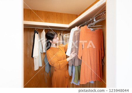 一位女士選擇穿的衣服 123948044