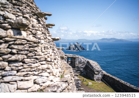 Ancient stone walls overlook Irish sea stacks. Skellig Michael 123948515