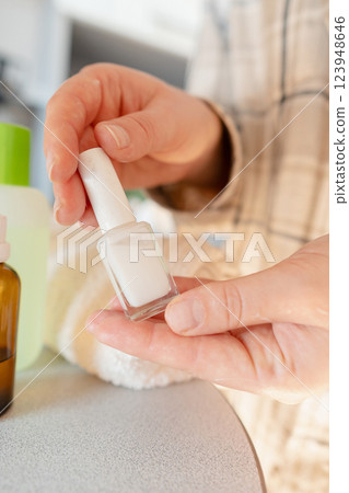 Nail restoration process: pushing back cuticles and applying vitamin serum to strengthen weak nails. 123948646