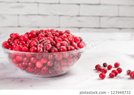 Frozen cranberries in transparent bowl, on light background. Preservation of vegetables and fruits. Natural products Frozen cranberries in transparent bowl, on light background. Preservation of vegetables and fruits. Natural products 123948732