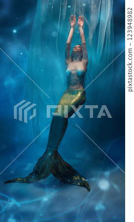 Graceful, elegant young woman, mermaid surrounded by delicate veils, floating in a dreamlike atmosphere Graceful, elegant young woman, mermaid surrounded by delicate veils, floating in a dreamlike atmosphere 123948982