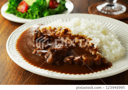 Beef curry and green salad 123948995