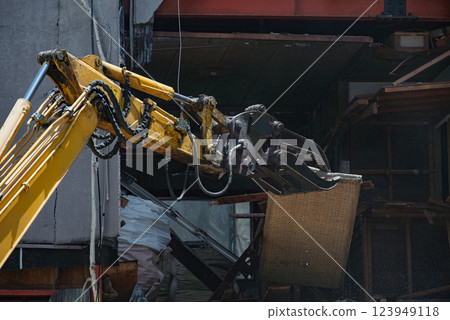 Heavy machinery removing tatami mats during the demolition of an empty house 123949118