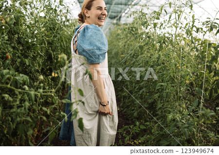 Closeup of a young attractive female farmer checking the ripe fruits of black tomatoes Closeup of a young attractive female farmer checking the ripe fruits of black tomatoes 123949674