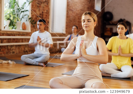Group of young sporty attractive people practicing yoga lesson with instructor 123949679
