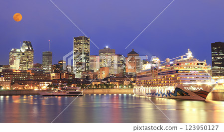 Montreal skyline illuminated at dusk with a cruise boat on the foreground Montreal skyline illuminated at dusk with a cruise boat on the foreground 123950127