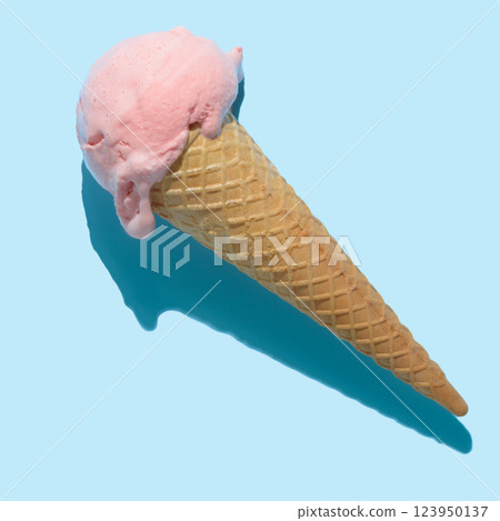 top view of pink ice cream cone with hard shadow isolated on blue, minimal summer concept top view of pink ice cream cone with hard shadow isolated on blue, minimal summer concept 123950137