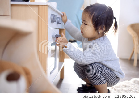 A little Asian girl is playing in the bedroom at home. A cute Korean baby in a kindergarten. 123950205