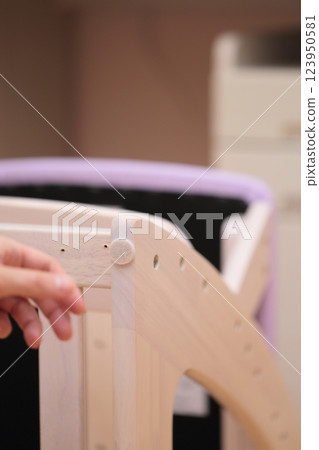 A man putting anti-scratch stickers on the legs of his desk chair 123950581