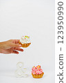 Two shortbread cakes with cream. One cake in a woman's hand. White background. 123950990