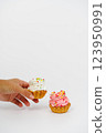 Two shortbread cakes with cream. One cake in a woman's hand. White background. 123950991