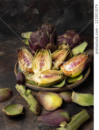 Plate full of cut purple raw artichokes closeup. Fresh italian vegetables from farmers market Plate full of cut purple raw artichokes closeup. Fresh italian vegetables from farmers market 123951074