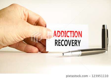 Addiction recovery symbol. Concept words Addiction recovery on beautiful white card. Psychologist hand. Beautiful white paper background. Psychology addiction recovery concept. Copy space. 123951110