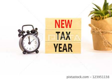 New tax year symbol. Concept words New tax year on beautiful wooden blocks. Beautiful white background. Black alarm clock. Business new tax year concept. Copy space. 123951138