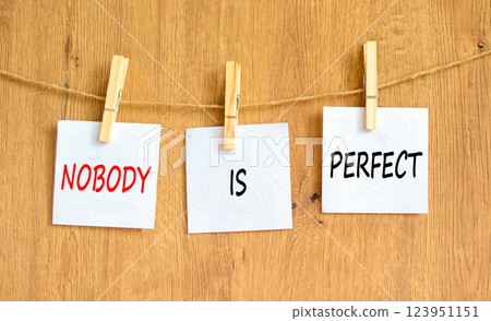 Nobody is perfect symbol. Concept words Nobody is perfect on beautiful white paper on clothespin. Beautiful wooden background. Business motivational lifestyle and nobody is perfect concept. Copy space 123951151
