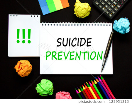 Suicide prevention symbol. Concept words Suicide prevention on beautiful white note. Black calculator. Colored pencils. Beautiful black background. Psychological suicide prevention concept. Copy space 123951213
