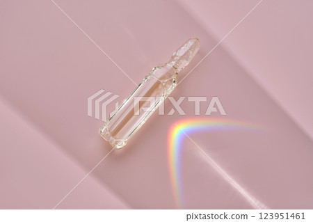 An ampoule with a medical product or cosmetic product on a pink background. An ampoule with a medical product or cosmetic product on a pink background. 123951461