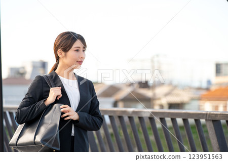 Smiling businesswoman on the riverbank Smiling businesswoman on the riverbank 123951563