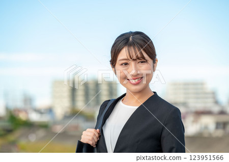 Smiling businesswoman with blue sky background 123951566