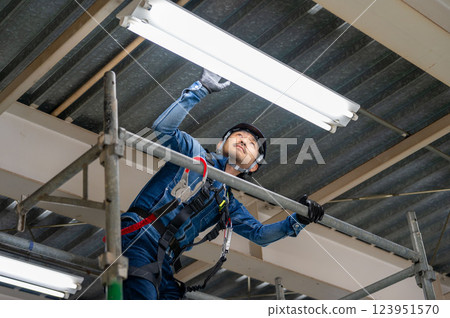 一名男子在高空檢查電力 一名男子在高空檢查電力 123951570