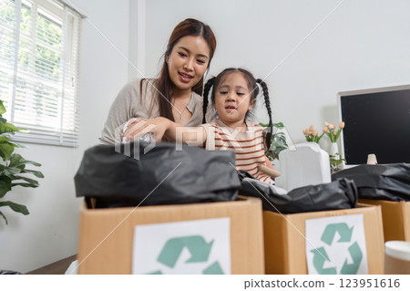Family Bonding and Environmental Responsibility. A mother teaching her daughter about recycling. 123951616