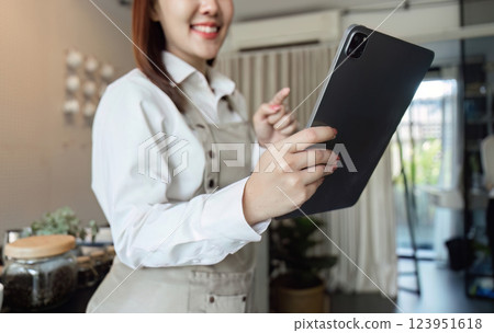 Digital Management in Coffee Shops. A barista interacts with a tablet, enhancing customer experience. 123951618