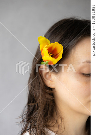 face of a woman with tulip flower in her hair. florist, flower shop. bouquet of flowers 123951985