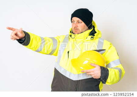 a man wearing a yellow working winter jacket and a yellow safety helmet . High quality photo a man wearing a yellow working winter jacket and a yellow safety helmet . High quality photo 123952154