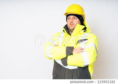a man wearing a yellow working winter jacket and a yellow safety helmet . High quality photo 123952182