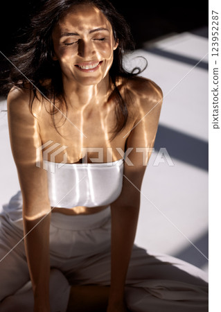 Studio fashion portrait of a charming young woman sitting with her eyes closed Studio fashion portrait of a charming young woman sitting with her eyes closed 123952287