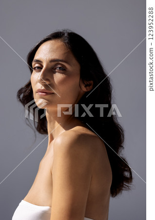 studio portrait of an attractive young woman on a gray background studio portrait of an attractive young woman on a gray background 123952288