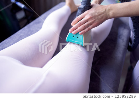 Cosmetician using LPG slimming apparatus on body 123952289