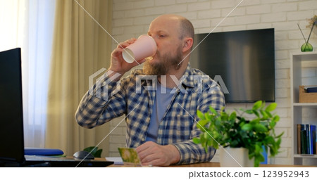 Bald man working at desk embraces comfort in home office, comfort fueling creative focus while comfort eases tension, supporting daily productivity. Remote work of man at computer Bald man working at desk embraces comfort in home office, comfort fueling creative focus while comfort eases tension, supporting daily productivity. Remote work of man at computer 123952943