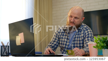 Remote professional freelancing, working on laptop at home workspace, sipping coffee with calm concentration, embodying modern digital nomad lifestyle. Concept of caffeine as doping 123953067