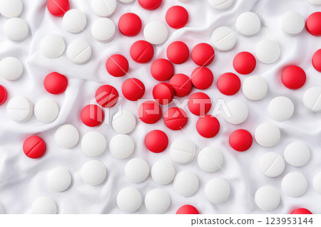 Colorful pills scattered on soft fabric background for medicinal and health topics. 123953144